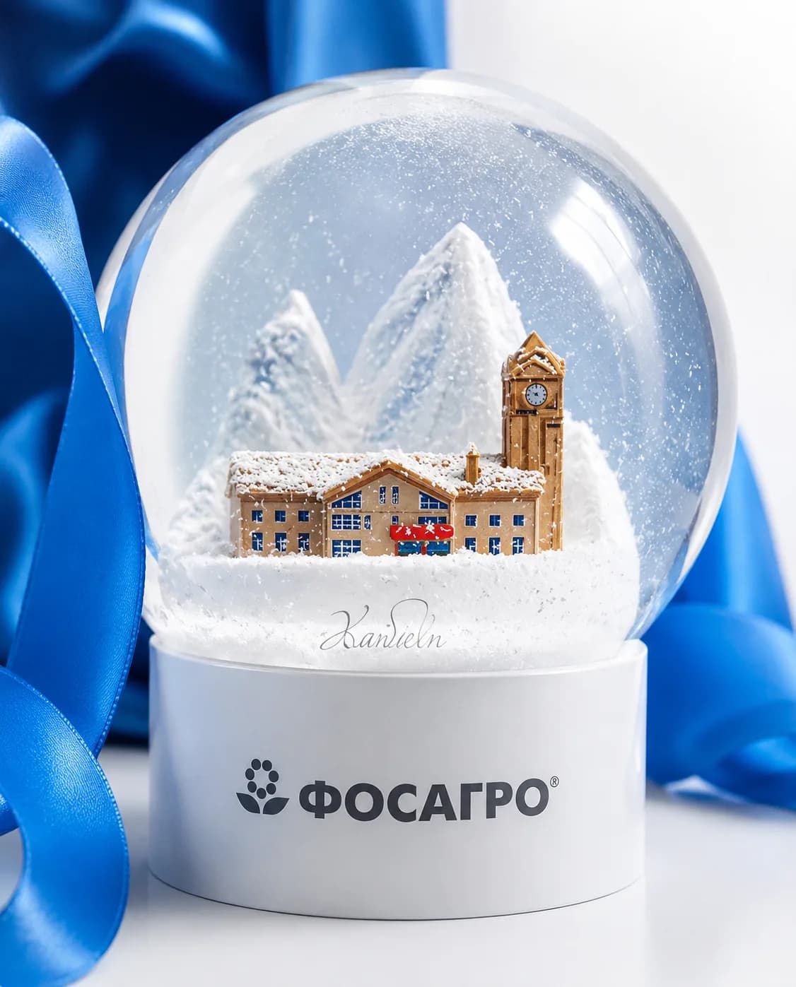 Снежный шар с горами и городской застройкой, на белом основании с логотипом «Фосагро»