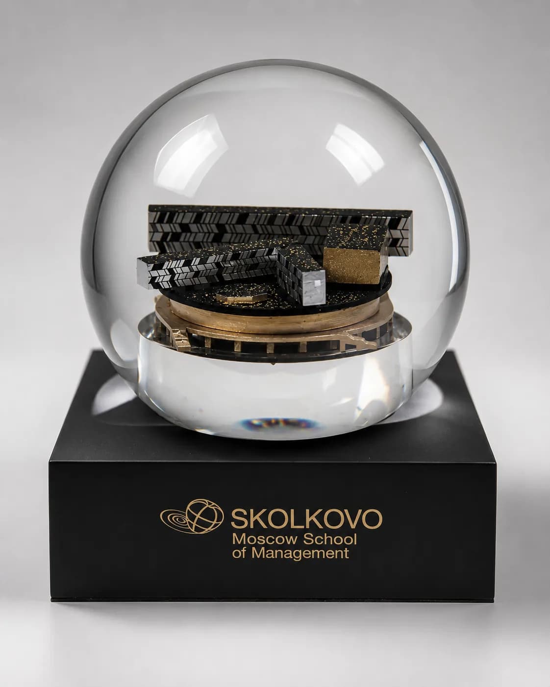 Снежный шар с макетом здания, на чёрном основании с логотипом «Сколково»